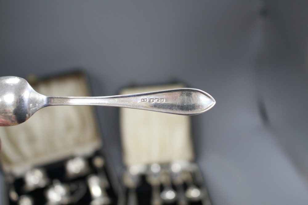 Four cased sets of silver, including pair of napkin rings, six grapefruit spoons, condiment set and pair of pepperettes.